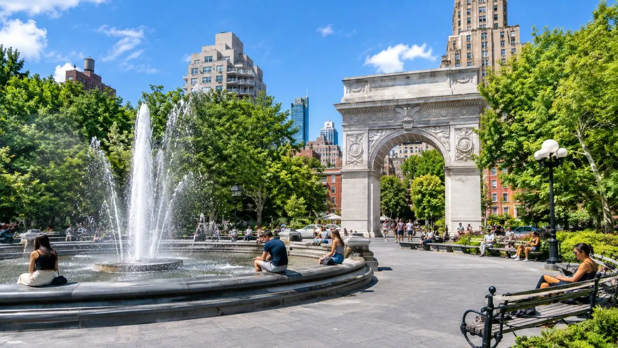 Washington Square Park mit dem Bogen, dem Brunnen und Menschen auf den Bänken